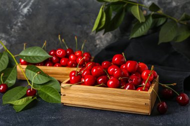 Koyu arkaplanda kirazlı ahşap kutular