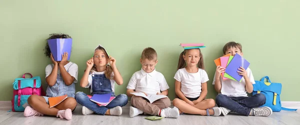 Niños Divertidos Con Copybooks Sentados Suelo Cerca Pared Verde — Foto de Stock