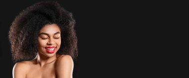 Koyu arka planda güzel bir Afro-Amerikalı kadın portresi.