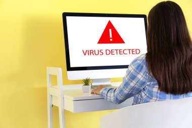 Evde bilgisayar üzerinde çalışan genç bir kadın. Antivirüs konsepti