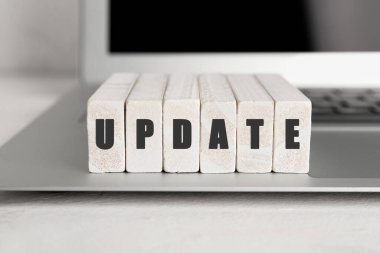 Masadaki tahta bloklardan yapılmış dizüstü bilgisayar ve kelime UPDATE