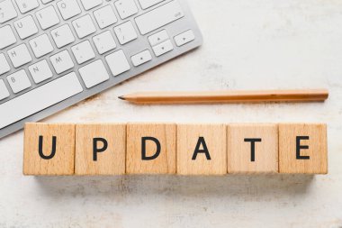 Işık arkaplan üzerinde küp ve PC klavyesinden oluşan kelime UPDATE