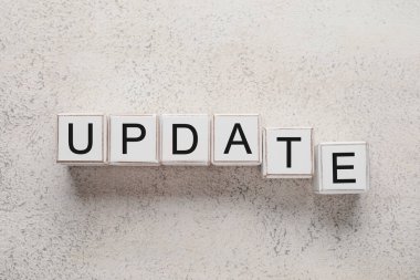 Işık arkaplanındaki küplerden oluşan kelime UPDATE