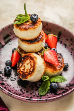 Süzme peynirli krep, taze böğürtlen ve nane yapraklı tabak.