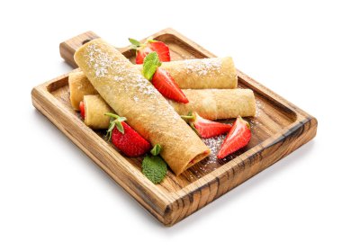 Beyaz arka planda ince krep, çilek ve nane yapraklı tahta.