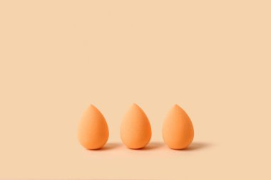 Renkli arkaplanda turuncu makyaj süngeri