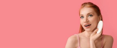 Pembe arka planda makyaj süngeri olan güzel bir kadın ve metin için yeri var.