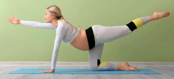 Mujer Embarazada Joven Haciendo Pilates Cerca Pared Verde — Foto de Stock