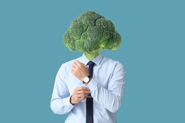 Hombre Con Brócoli Fresco Lugar Cabeza Sobre Fondo Azul —  Fotos de Stock