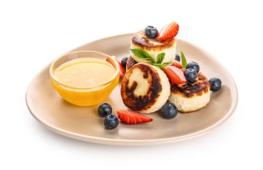 Lezzetli süzme peynirli krep, böğürtlen, nane yaprağı ve bal beyaz arka planda.