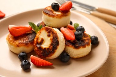 Süzme peynirli krep, böğürtlen ve nane yapraklı tabaklar ahşap tahtada, yakın plan