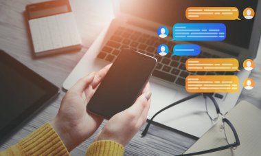 Cep telefonlu bir kadın iş yerinde internette sohbet ediyor.