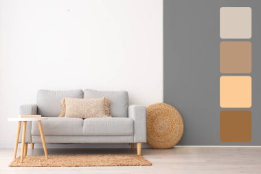 Şık bir kanepe ve ışık duvarının yanındaki masa. Farklı renk desenleri