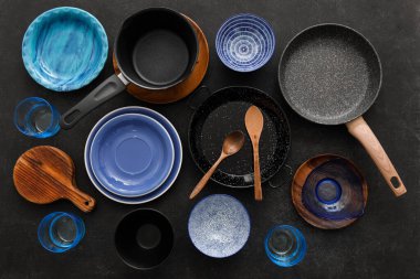 Koyu arkaplanda şık yemek takımları ve mutfak aletleri