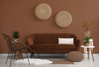 Modern oturma odasının içinde şık bir kanepe, masa ve hasır koltuk.