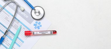 Maymun çiçeği virüsü örneği, sağlık sigortası boş ve beyaz arka planda steteskop.