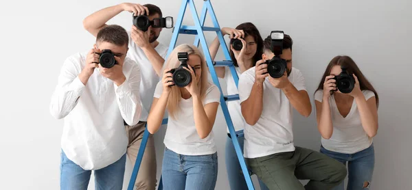 Grupo Jóvenes Fotógrafos Cerca Escalera Sobre Fondo Claro — Foto de Stock