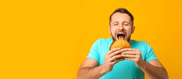 Uomo Mangiare Gustoso Hamburger Sfondo Giallo Con Spazio Testo — Foto Stock