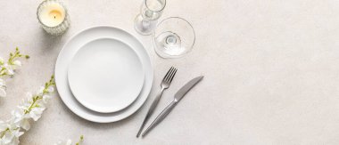 Açık arkaplanda çiçek dekoru ve metin için yeri olan güzel masa ayarları, üst görünüm