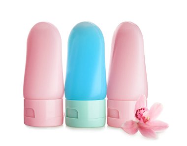 Beyaz arka planda farklı kozmetik ürünleri ve orkide çiçekleri