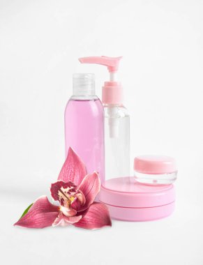 Beyaz arka planda doğal kozmetik ürünleri ve orkide çiçeği