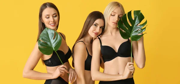 Mooie Jonge Vrouwen Ondergoed Met Tropische Monstera Bladeren Gele Achtergrond — Stockfoto