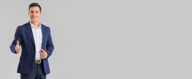 İş adamı el sıkışmak için gri arkaplan ve metin için boşluk veriyor