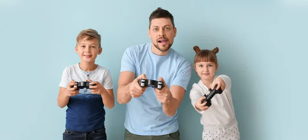 Padre Sus Hijos Pequeños Jugando Videojuegos Sobre Fondo Azul Claro —  Fotos de Stock