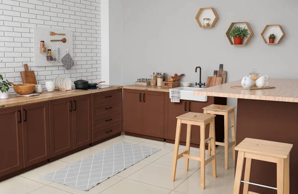 Interior of light kitchen with brown furniture