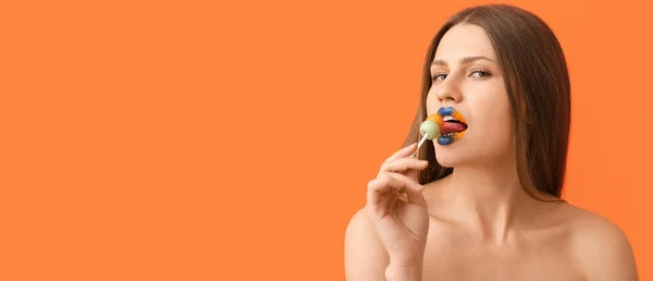 Hermosa Mujer Joven Con Maquillaje Creativo Piruleta Sobre Fondo Naranja — Foto de Stock