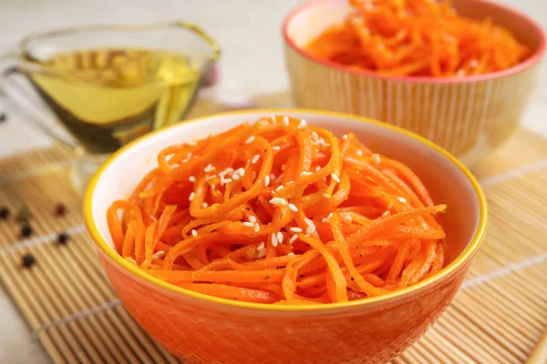 Bowls with tasty korean carrot salad, closeup