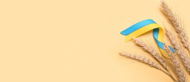 Bej arkaplan üzerinde Ukrayna bayrağı renginde buğday başlıkları ve kurdeleler metin için boşluk