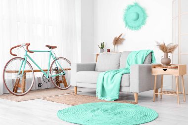 Rahat gri kanepe ve bisiklet oturma odasının iç tarafında.