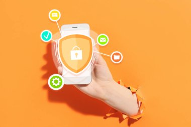 Turuncu arka planda cep telefonu olan bir kadın. Antivirüs konsepti