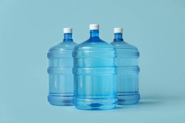 Açık mavi zemin üzerinde temiz su şişeleri