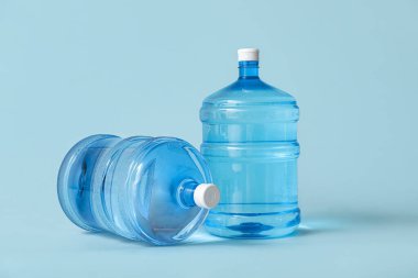 Açık mavi zemin üzerinde temiz su şişeleri