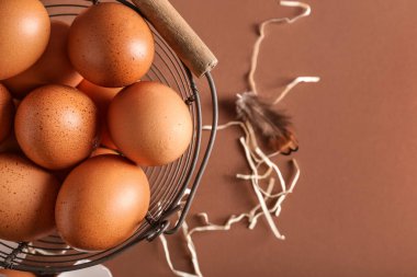 Arka planda kahverengi tavuk yumurtası olan sepet, yakın plan.