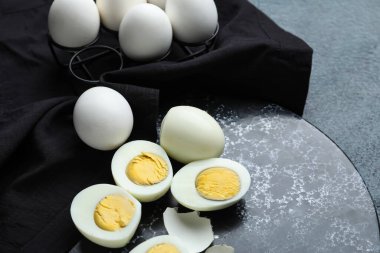 Koyu arka planda haşlanmış tavuk yumurtası olan tahta, yakın plan.