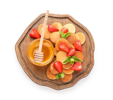 Tahta tahta tahta tahta pankek, çilek ve beyaz arka planda bir kase bal