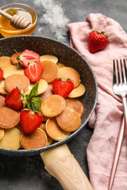 Mini krepli tava ve grunge arkaplanda çilek.