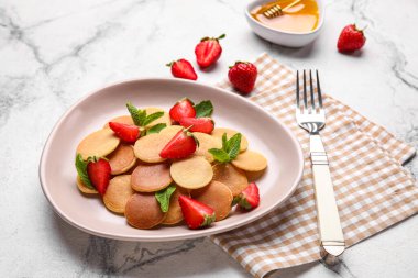 Hafif arka planda çilekli lezzetli mini krepler.