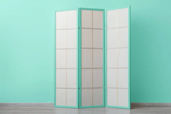 Stylish folding screen near mint wall in room