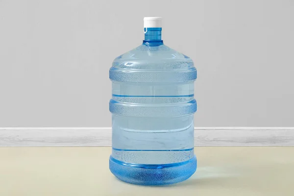 Bottle of clean water on floor near light wall