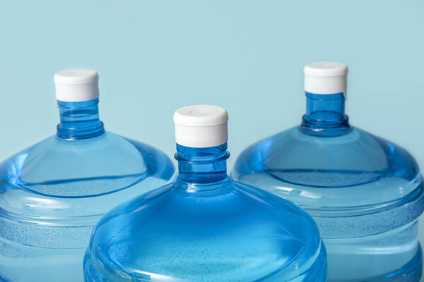 Bottles of clean water on light blue background, closeup