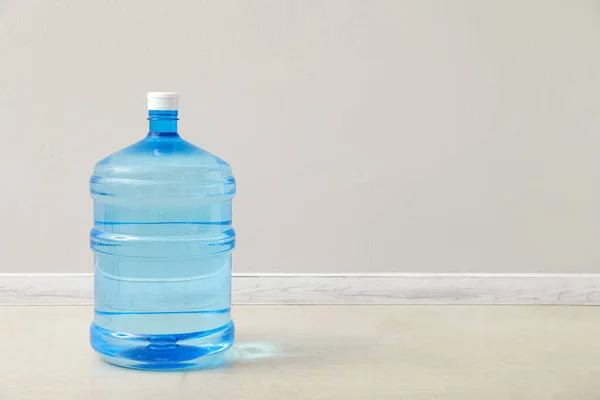 Bottle of clean water on floor near light wall