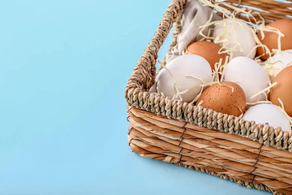 Ψάθινο Καλάθι Διαφορετικά Αυγά Κοτόπουλου Στο Φόντο Χρώμα Closeup — Φωτογραφία Αρχείου