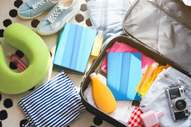 Seyahat için giysi ve aksesuarlarla dolu bavulu açtık.