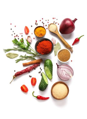 Beyaz arka planda farklı baharat ve sebzelerle güzel bir kompozisyon.