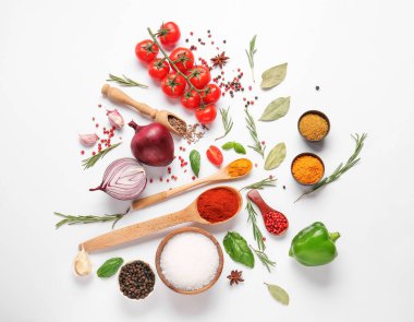 Beyaz arka planda farklı baharatlar, otlar ve sebzeler içeren kompozisyon