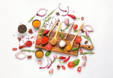 Beyaz arka planda farklı baharatlar, otlar ve sebzelerle güzel bir kompozisyon.